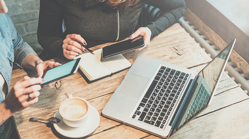 Dwie osoby korzystają z Elavon Connect na urządzeniach mobilnych